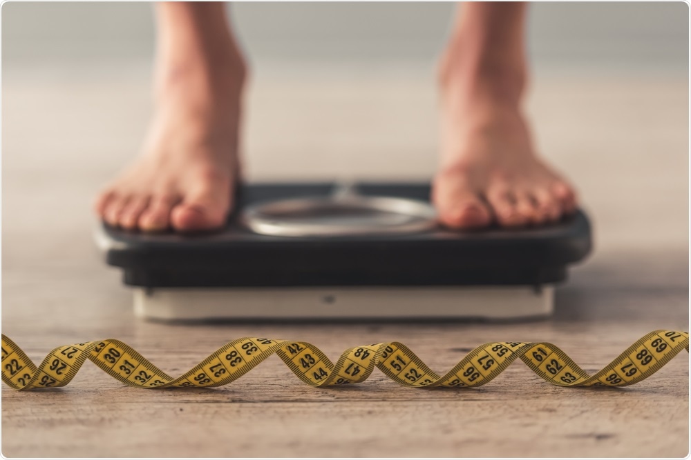 Person with an eating disorder standing on weighing scales.